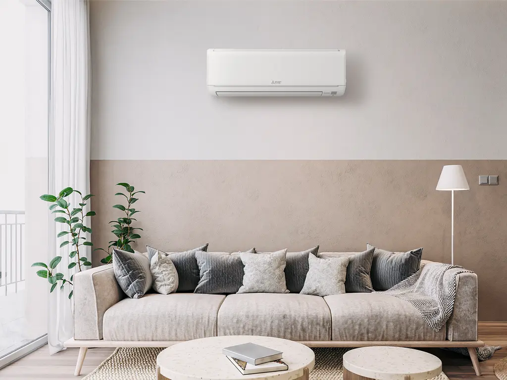A ductless mini-split head mounted on a living-room wall.