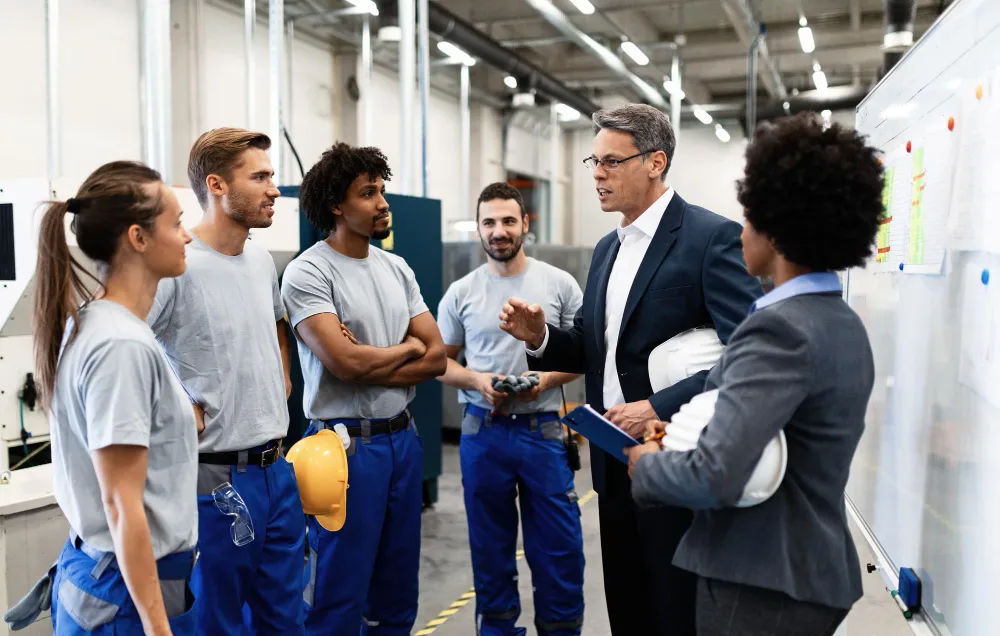 An HVAC crew being briefed by a manager at a whiteboard.